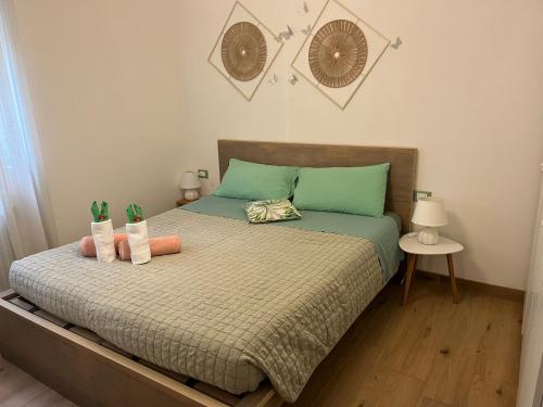 a bedroom with a bed with green and pink pillows at Lake Apartment Ischia Green, Lago di Caldonazzo in Tenna 
