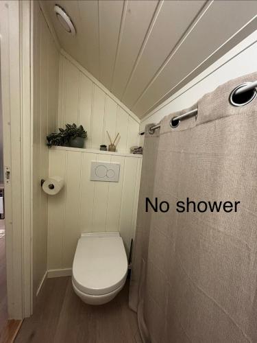 a bathroom with a toilet with a no shower sign at Loftsrom in Drammen