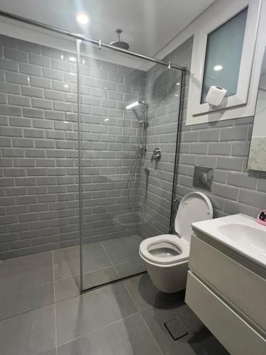 a bathroom with a shower and a toilet and a sink at Bait Al Marina in Salalah