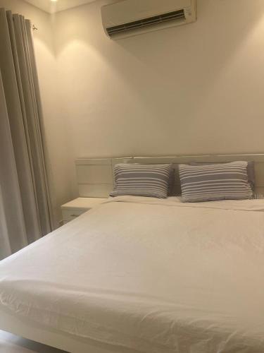 a white bed with two pillows on top of it at Bait Al Marina in Salalah
