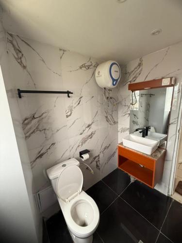 a bathroom with a white toilet and a sink at Etienne Gae 2 in Douala