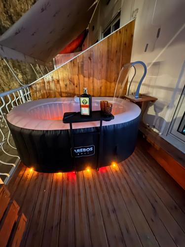 a large bath tub sitting on a deck with lights at Romance Apartments in Sarandë