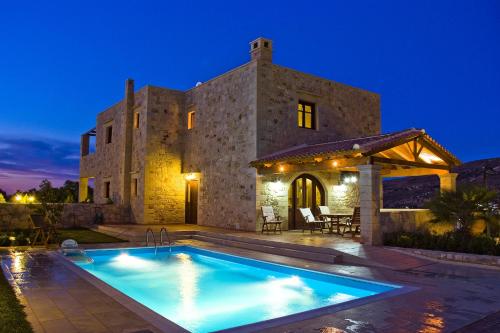 une villa avec une piscine en face d'un bâtiment dans l'établissement Adam Villas, à Falasarna