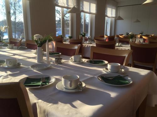 Komenský Gäste- und Tagungshaus في Herrnhut: طاولة عليها أكواب وصحون في مطعم