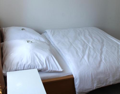 a bed with two white pillows on top of it at Royal Racing Suite Top 1 near Red Bull Ring in Judenburg