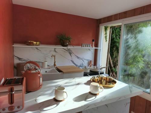 a kitchen with red walls and a counter with a sink at La suite mahradja in Quimper