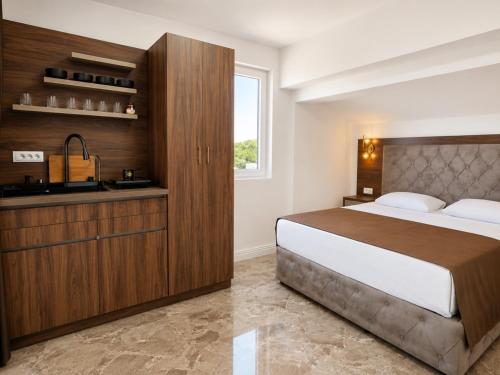 a bedroom with a large bed and a sink at Apartmani Enydoo in Ulcinj