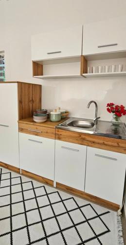 a kitchen with white cabinets and a sink at Nadia's home in Ilidža