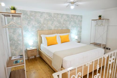 a bedroom with a large bed with orange pillows at Victry's Houses Chiaia in Naples