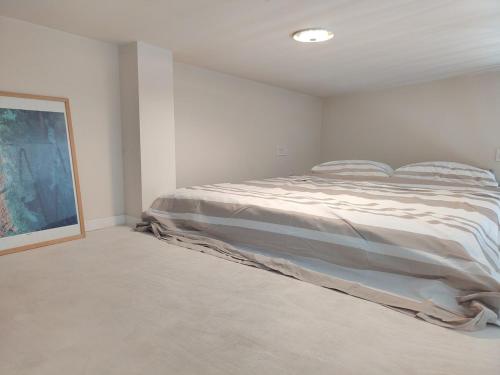 a bedroom with a bed in a white room at Mini Condos 2 Studio-Loft with garden in Mrčevac