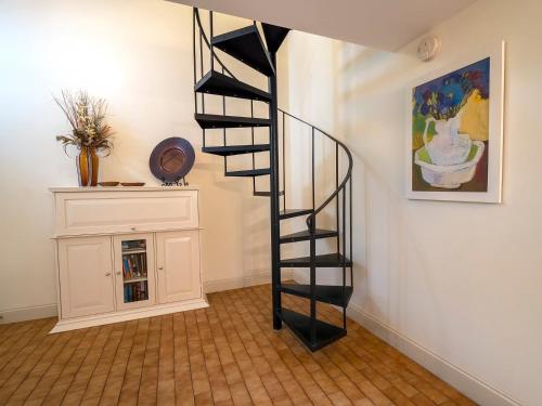 a black spiral staircase in a room with a cabinet at 1248 Creekwatch Villa in Seabrook Island
