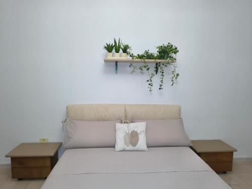 a bed with a white pillow and two tables at casa vacanza in Laterza