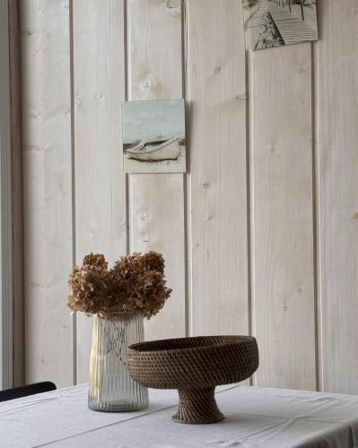 a table with a vase and a chair on it at HARMONY Slow Living Stay in Bigauņciems