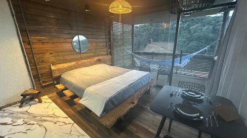 a bedroom with a bed in a room with a balcony at Front in Domingos Martins