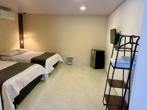 a hotel room with two beds and a television at Casa Arena San Andres in San Andrés