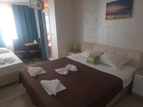 a hotel room with a bed with towels on it at Apartments Dani in Pomorie