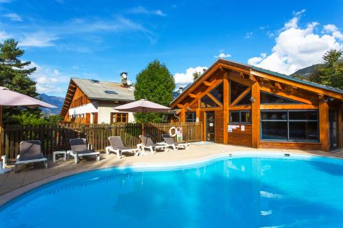 une maison avec une piscine en face d'une maison dans l'établissement Hotel-Restaurant Spa Les Peupliers, à Baratier