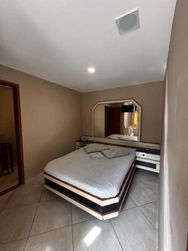 a bedroom with a bed and a large mirror at Grande Hotel in Duque de Caxias