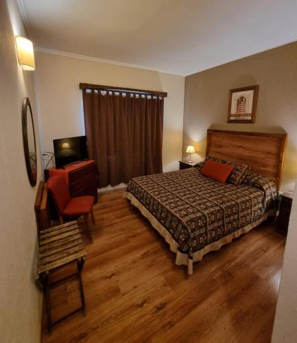 a bedroom with a bed and a chair and a television at Hotel Ideal Resto Bar in Colorado River