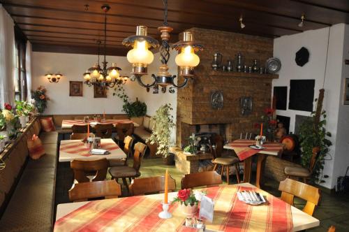 キルヒハイム・ウンター・テックにあるHotel Gasthof Ratstubeのテーブルと椅子、暖炉のあるレストラン