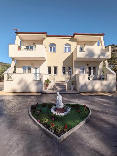 a large building with a statue in front of it at Harmony Sunset in Skala Sotiros