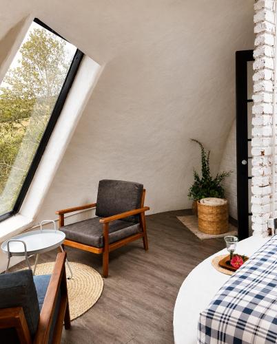 a attic room with a chair and a window at Hichata Breakfast Included in La Calera