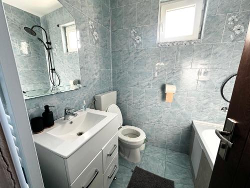 a bathroom with a white sink and a toilet at Casa Stefi in Copăceni