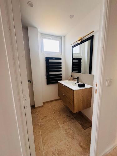 a bathroom with a sink and a mirror at Le Comptoir du Relais in Beine
