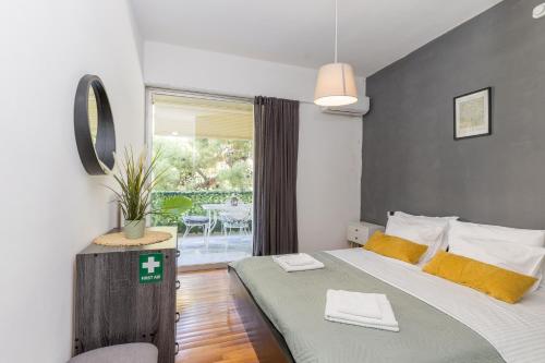 a bedroom with a bed and a window with a patio at Varkiza Beach Summerhouse-Athens Riviera in Vari