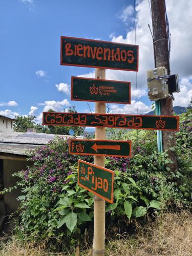 a street sign with many different signs on it at Cascada Sagrada in Pijao