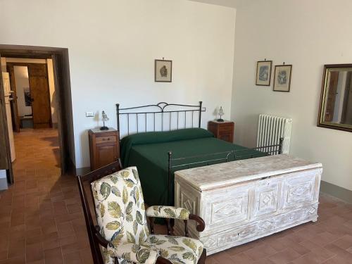 a bedroom with a green bed and a chair at Il Convento di Frida in Civitanova del Sannio