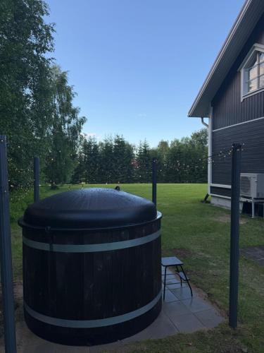 a large barrel sitting in a yard with a bench at Treeline Cottage in Rovaniemi
