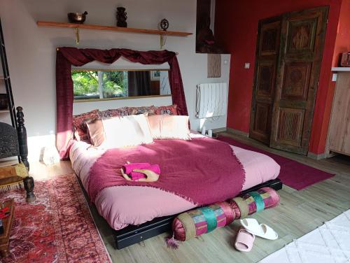a bedroom with a large bed with a pink blanket at La suite mahradja in Quimper