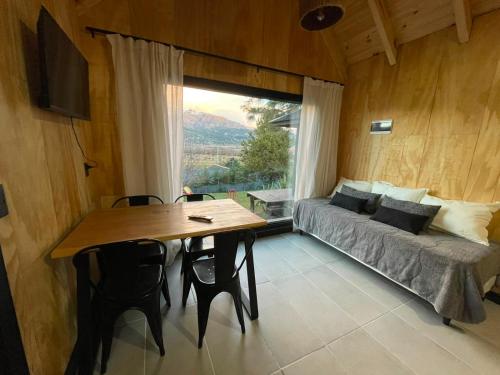 a room with a table and a couch and a window at cabaña wooden in San Martín de los Andes
