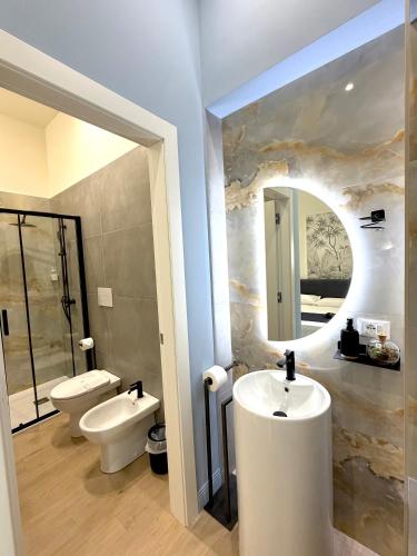 a bathroom with two toilets and a sink and a mirror at Xenia Suites Duomo in Reggio di Calabria