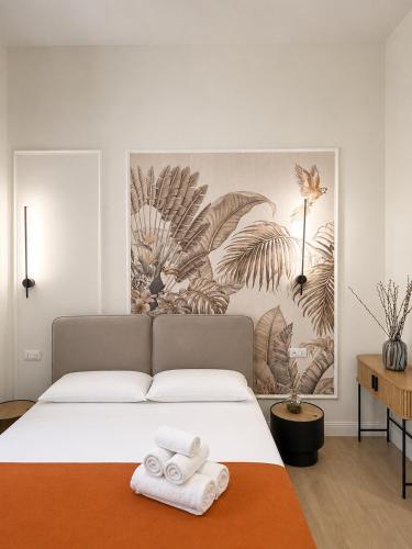 a bedroom with a large bed with towels on it at Xenia Suites Duomo in Reggio di Calabria