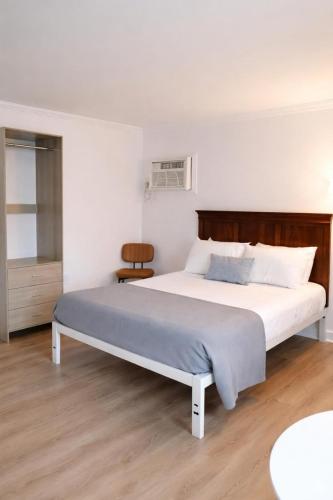 a bedroom with a large bed with a wooden headboard at Cape Harbor Motor Inn in Cape May