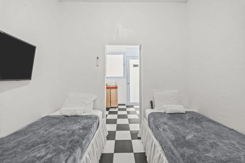 two beds in a room with a checkered floor at LISBD7D - JL Condado in San Juan