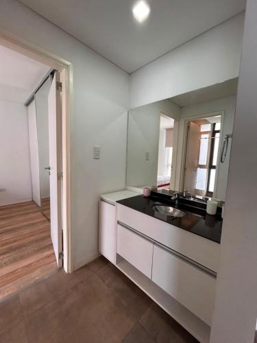 a white kitchen with a sink and a mirror at Emma in Villa Carlos Paz