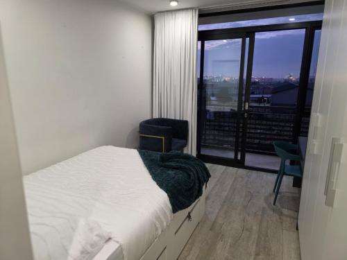 a bedroom with a bed and a large window at Kingsley at 1 on Albert in Cape Town