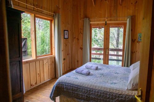 a bedroom with a bed with two pillows on it at Patagonia Mawida in Neltume