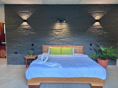 a bedroom with a large bed with a green pillow at Yalala Jacuzzi in Jabillos