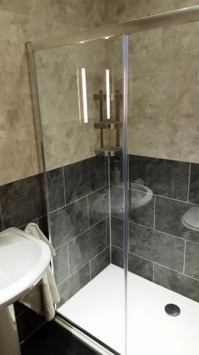 a bathroom with a shower and a sink at Boat House Super Suites in Rothesay