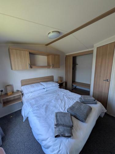 a bedroom with a large bed with towels on it at 69 Lighthouse View, Silver Sands Holiday Park in Lossiemouth