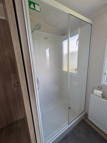 a shower with a glass door in a bathroom at 69 Lighthouse View, Silver Sands Holiday Park in Lossiemouth