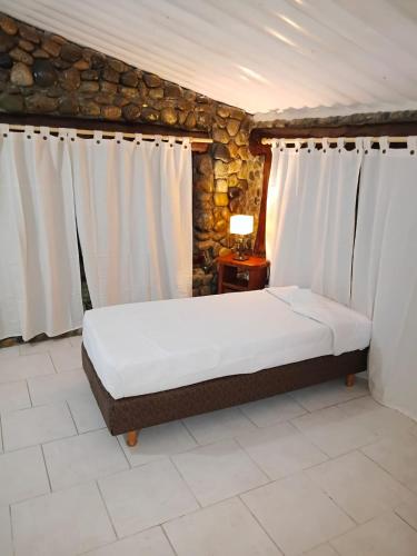 a bedroom with a bed with curtains and a table at Aurum patagonia hotel in Lago Puelo
