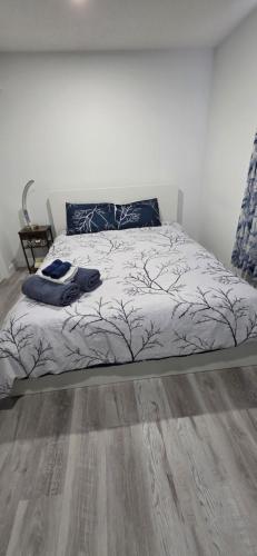 a bed in a bedroom with a wooden floor at Entire guest basement suite in Cochrane, AB in Cochrane