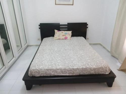 a bed with a black frame and a pillow on it at Marina tabarka in Tabarka
