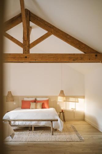 a bedroom with a bed and a wooden ceiling at L'Annexe Singulière in Maillé
