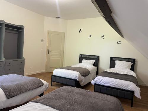 two beds in a room with birds on the wall at La Raimbauderie, villa 4 étoiles, avec clim, au coeur de la nature et des vignobles in La Chapelle-Montlinard